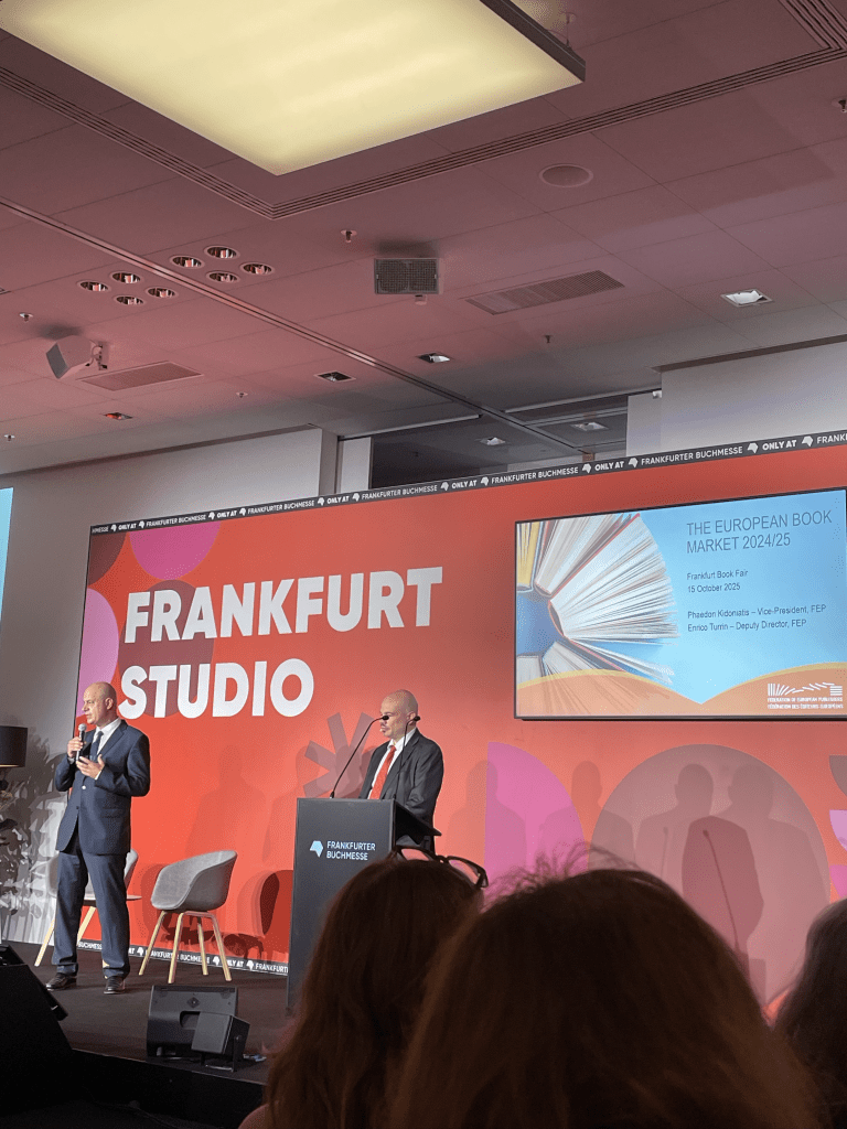 A presentation at the Frankfurt Book Fair showcasing the European Book Market data for 2024/25, featuring two speakers on stage in a conference setting.